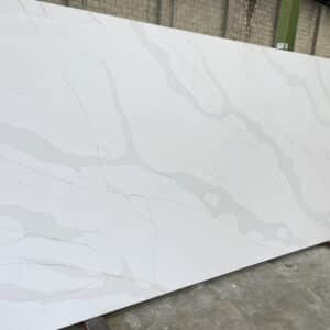 White marble slab with gray veining in a warehouse.