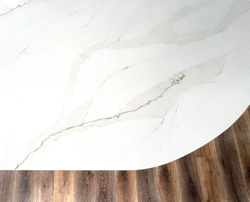 Marble countertop with golden veining on wooden floor.
