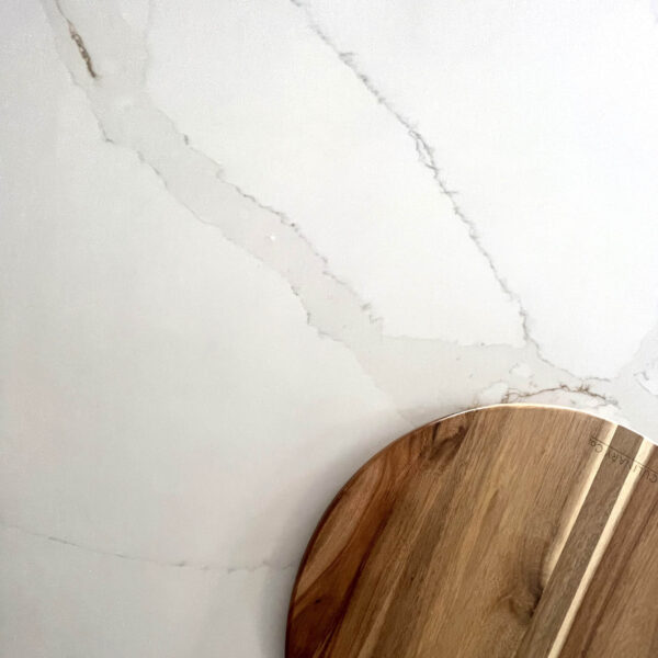 Marble countertop with wooden cutting board, showcasing Carrara Golden design.