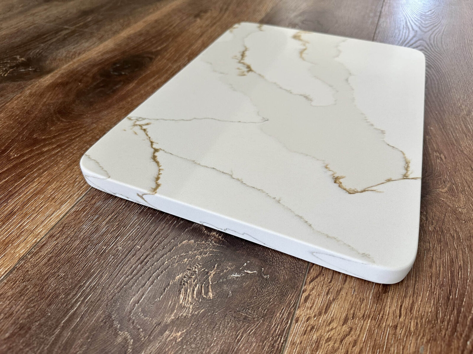 Marble-patterned cutting board on wooden surface.