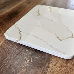 Marble-patterned cutting board on wooden surface.