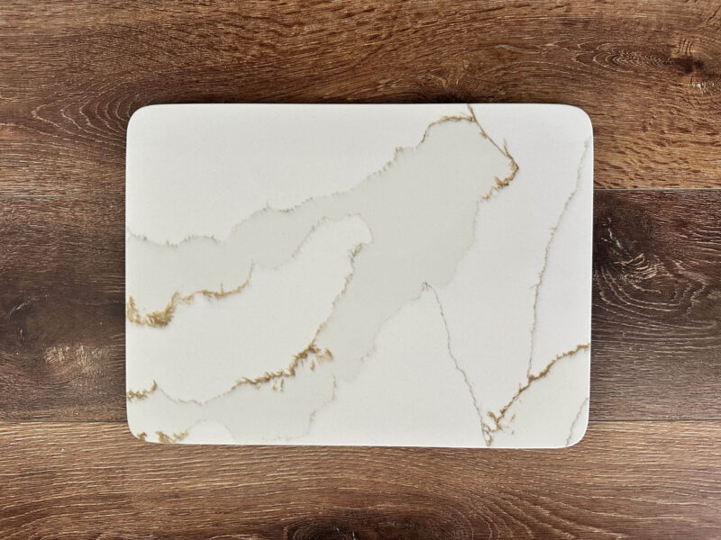 Marble-patterned rectangular cutting board on wooden surface.