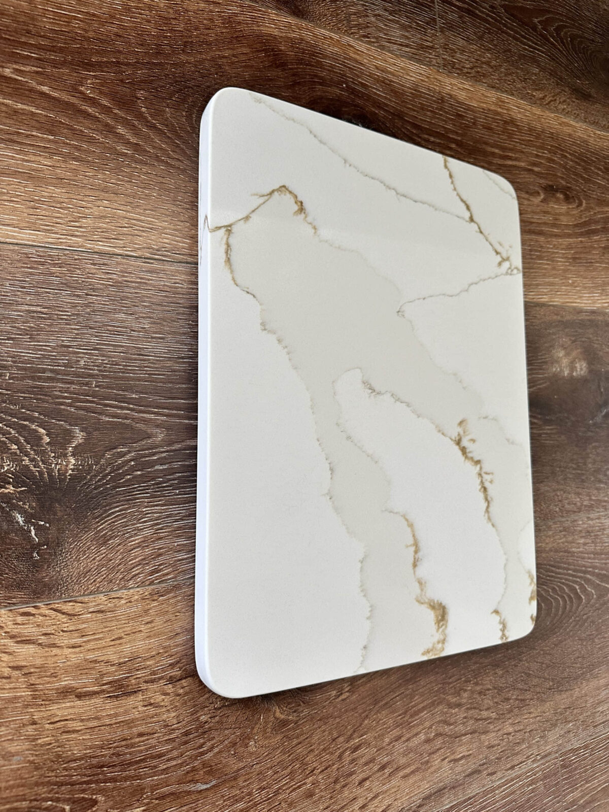 Marble cutting board on wooden kitchen counter.