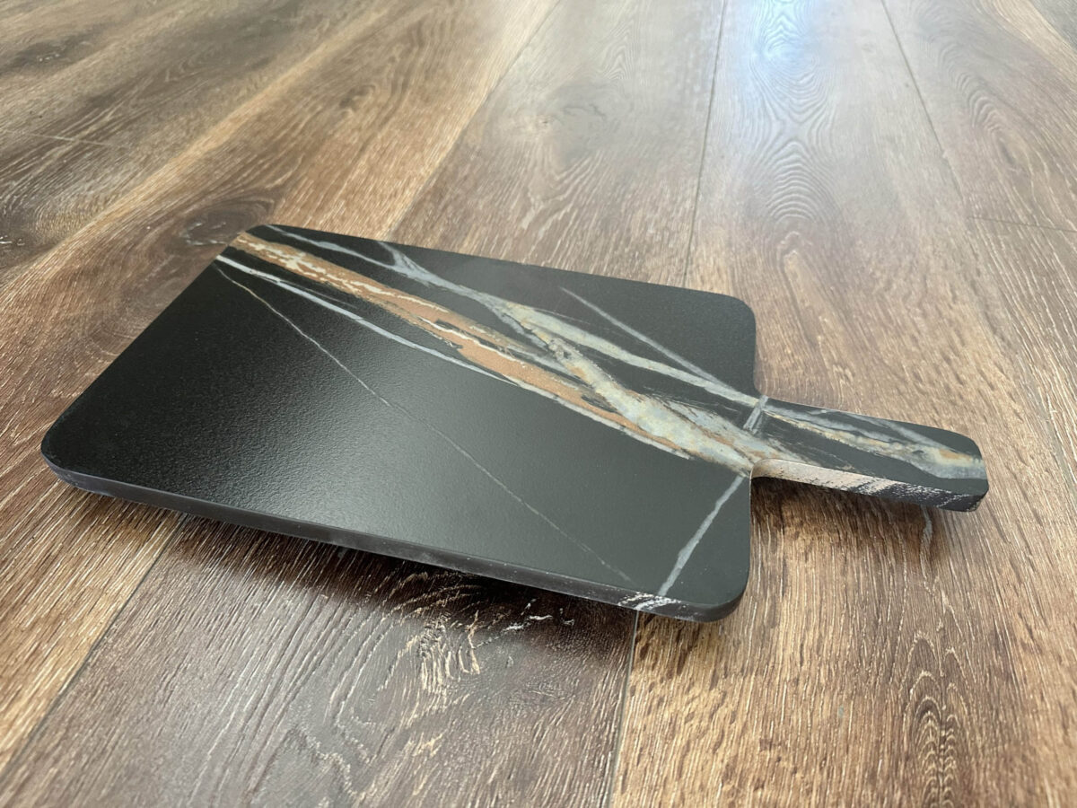 Marble cheese board on wooden floor.