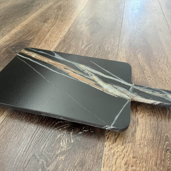 Marble cheese board on wooden floor.