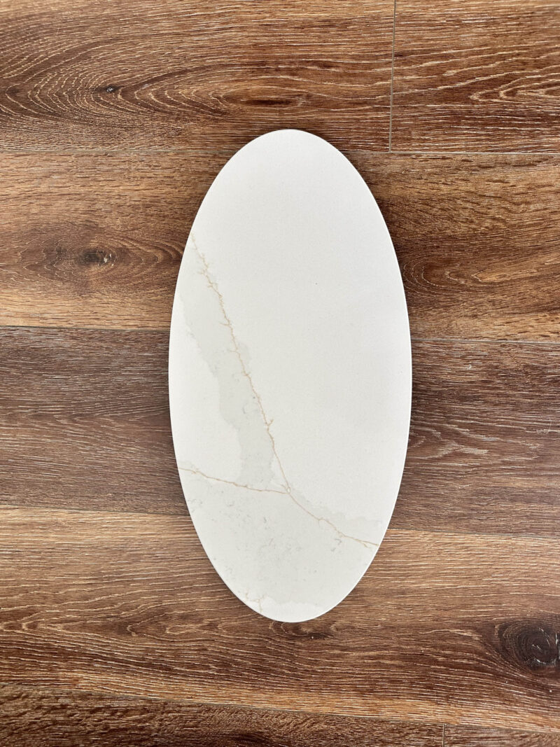 Oval marble plate on wooden table background.