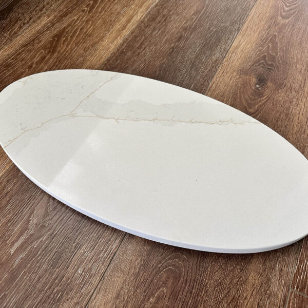 Oval marble serving platter on wooden table.