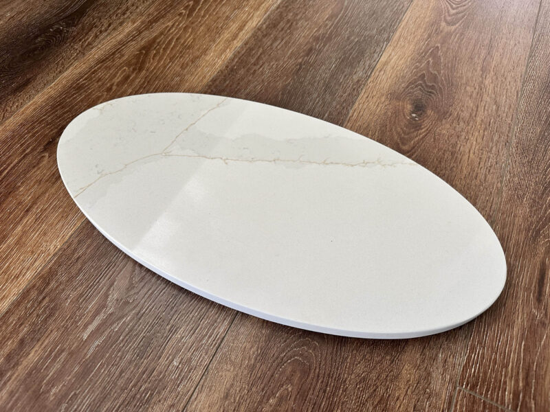 Oval marble serving platter on wooden table.