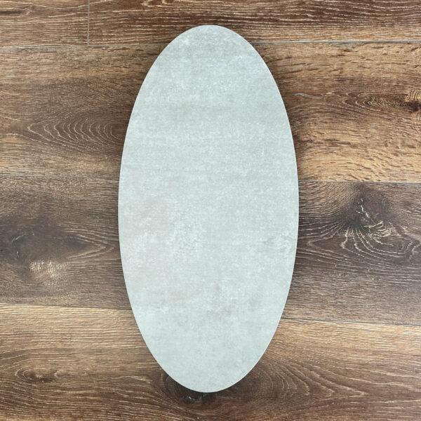 Oval-shaped ceramic plate on wooden floor background.