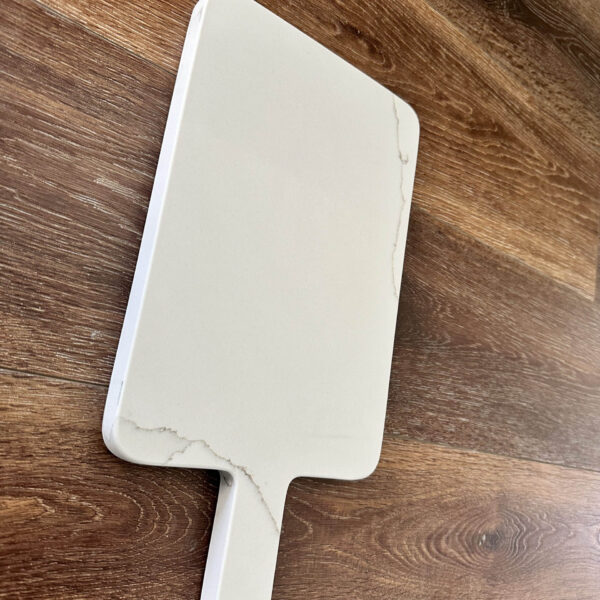 Marble cutting board on wooden surface.