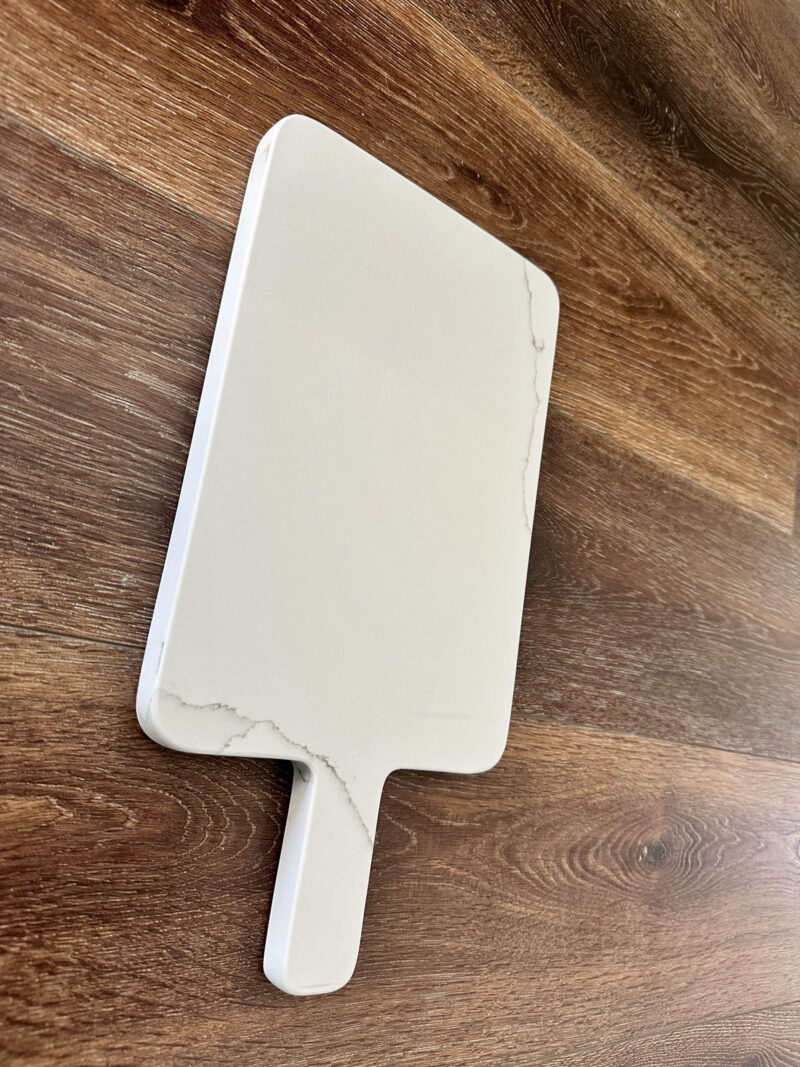 Marble cutting board on wooden surface.