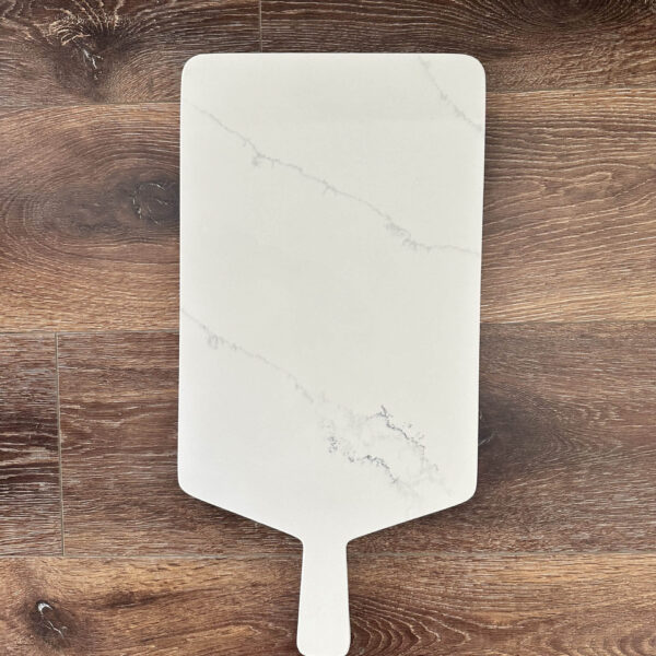 Marble cutting board on wooden surface.
