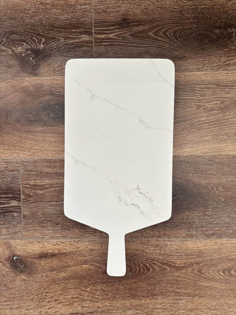 Marble cutting board on wooden surface.