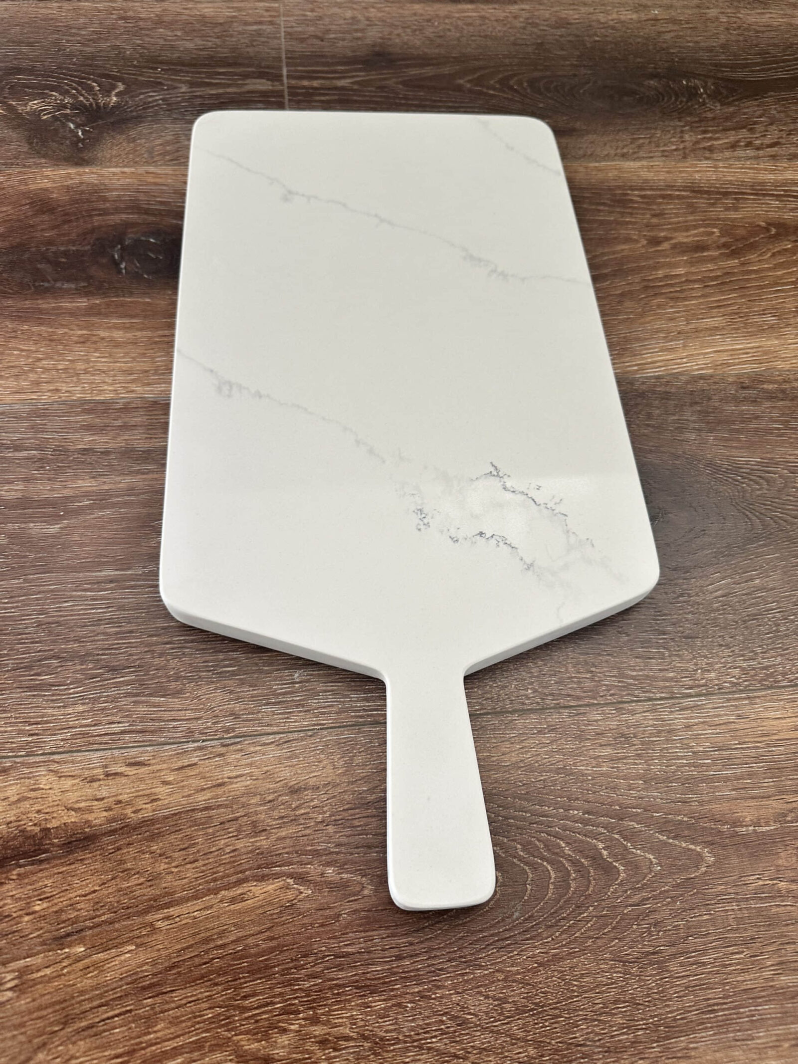 Marble cheese board on wooden table.