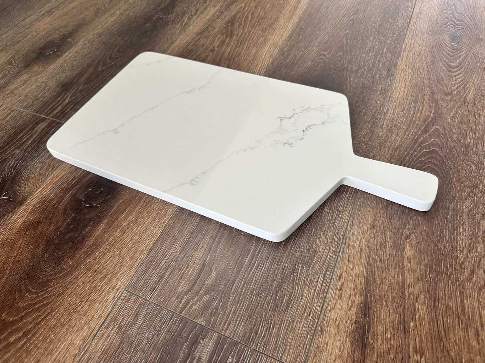 Marble cutting board on wooden floor.
