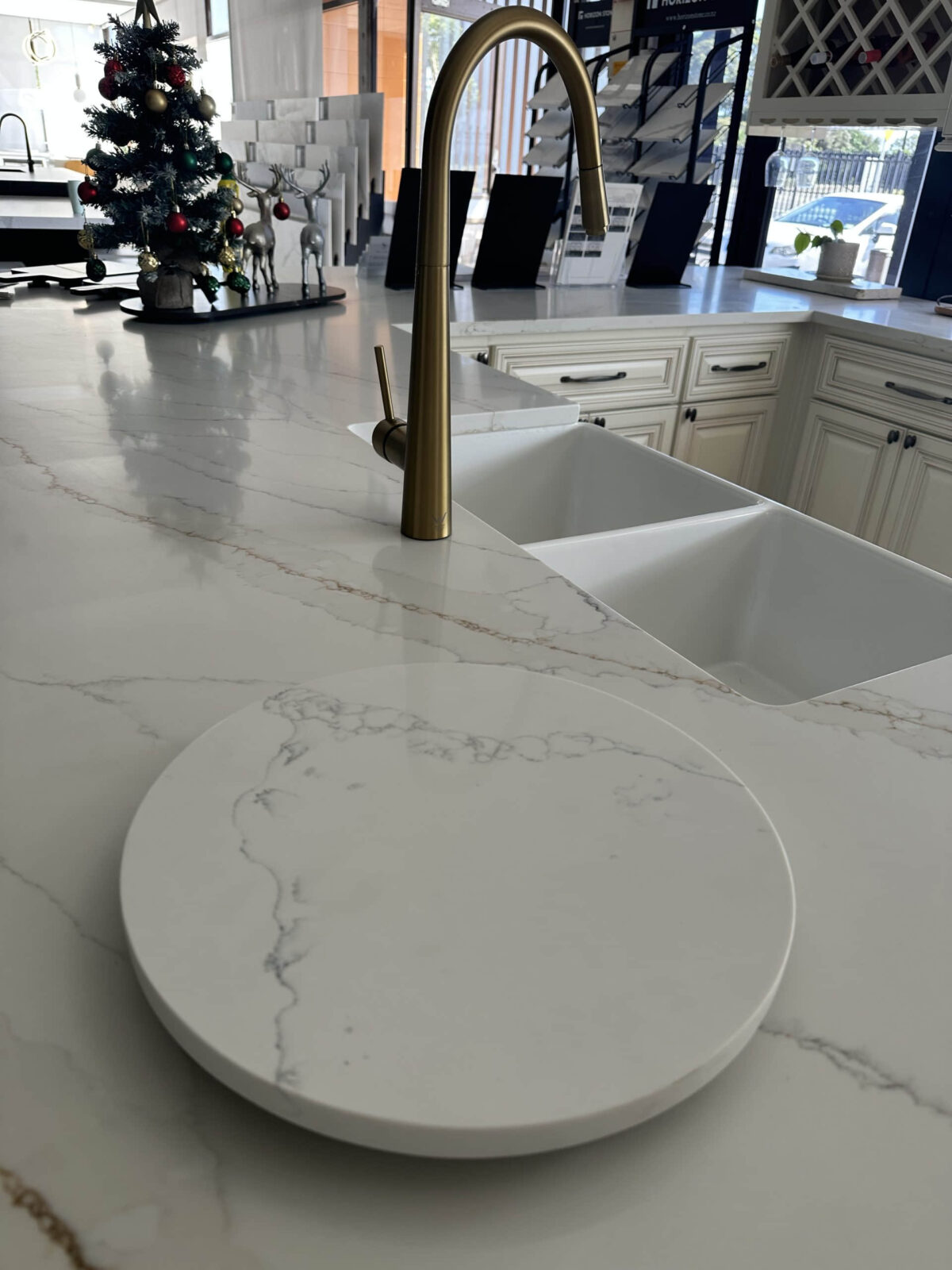 Modern kitchen with marble countertop and brass faucet.