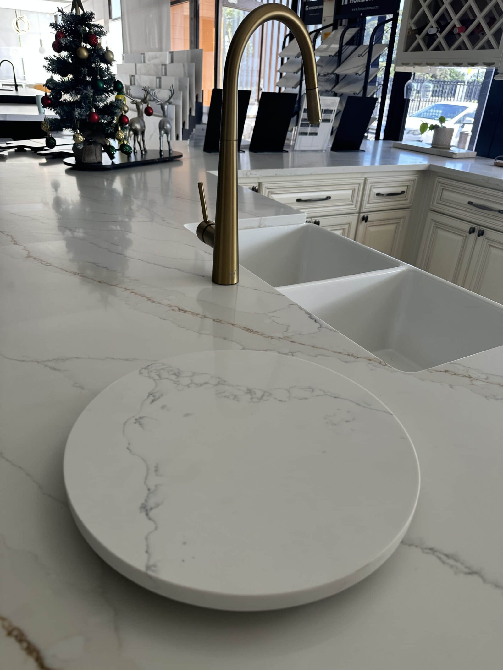 Modern kitchen with marble countertop and brass faucet.