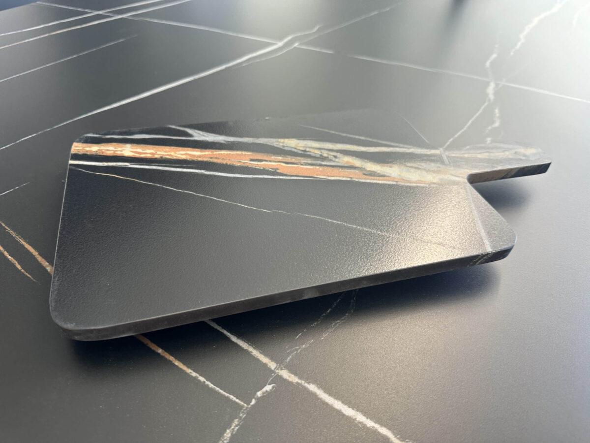 Marble kitchen countertop with a wooden cutting board.