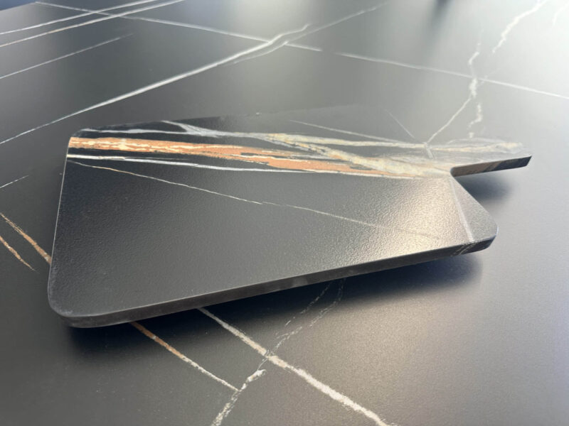 Marble kitchen countertop with a wooden cutting board.