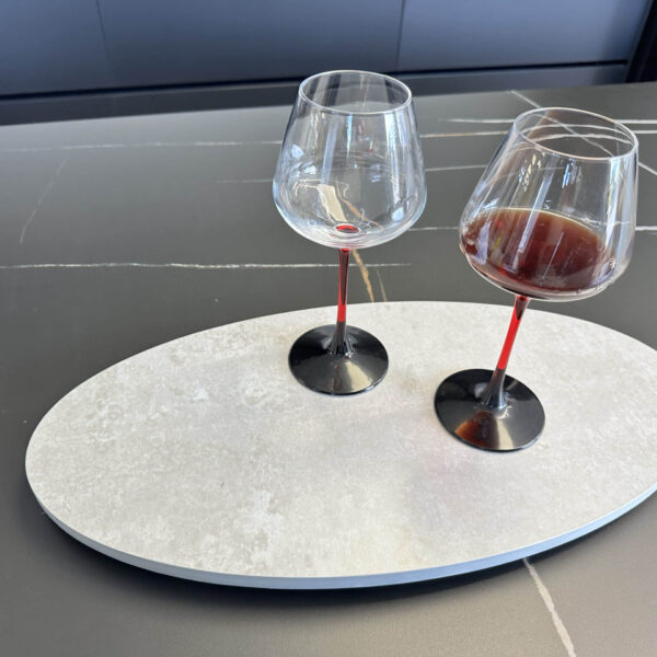 Two wine glasses, one empty, on a modern kitchen countertop.