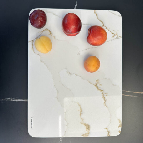 Five fruits on a marble cutting board.