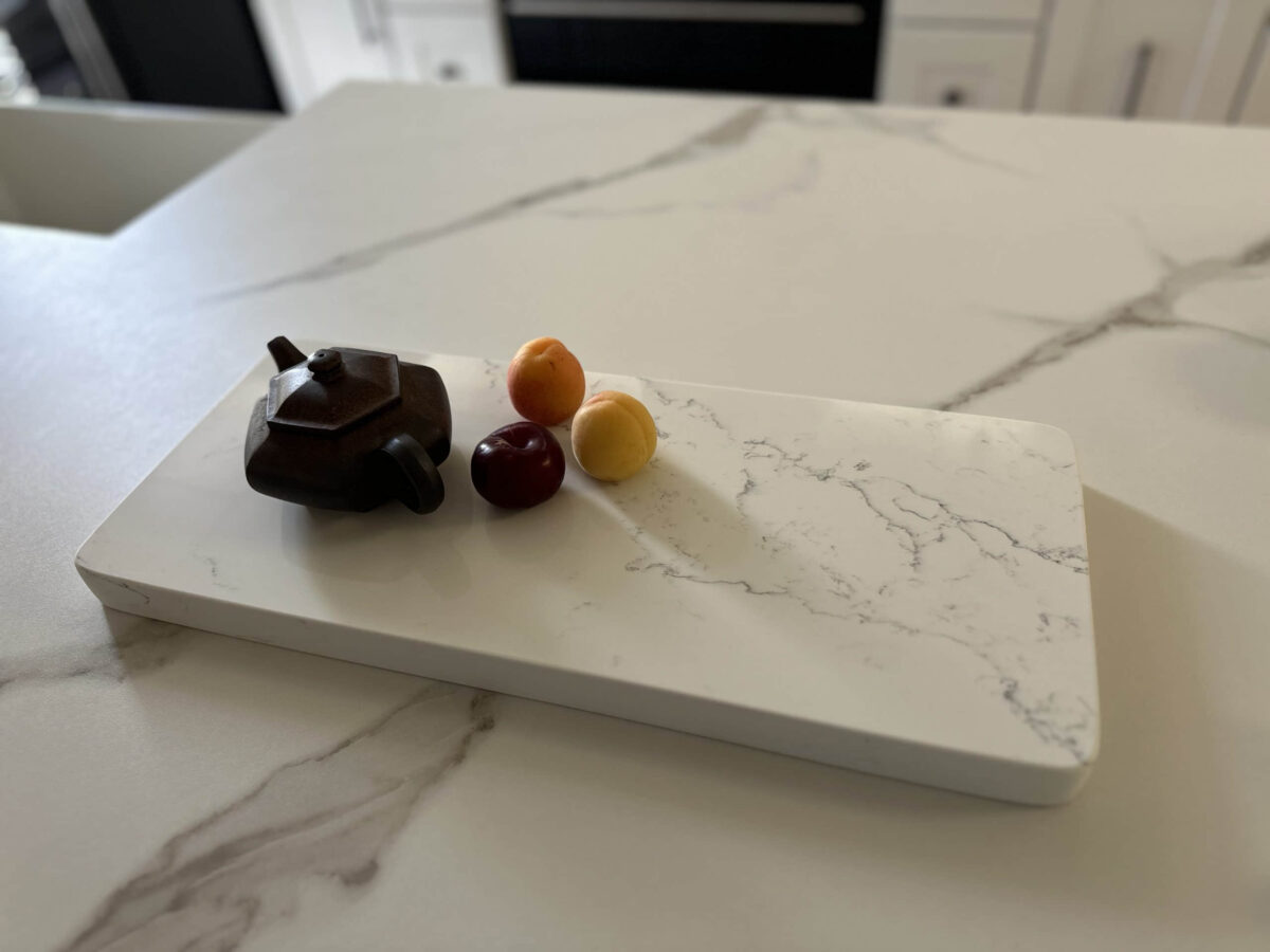 Teapot and fruit on marble kitchen counter.