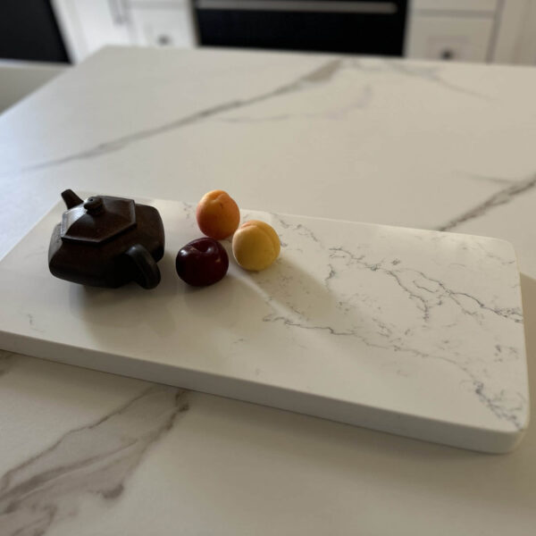 Teapot and fruit on marble kitchen counter.