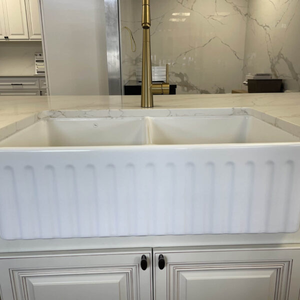 White farmhouse sink in a modern kitchen setting.