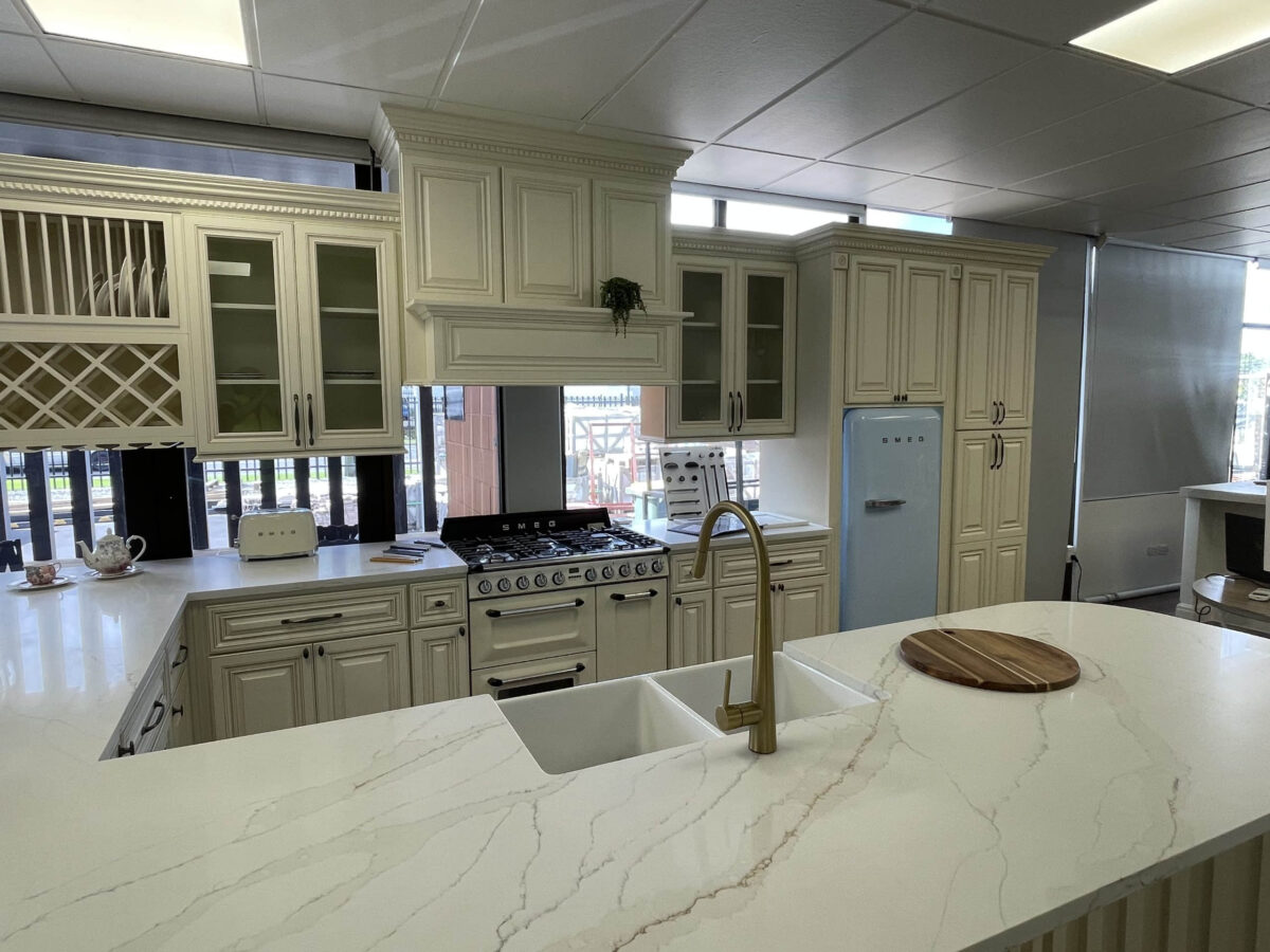 Modern kitchen with marble island, vintage fridge, and white cabinetry.