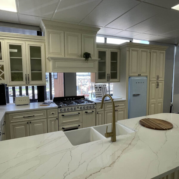 Modern kitchen with marble island, vintage fridge, and white cabinetry.