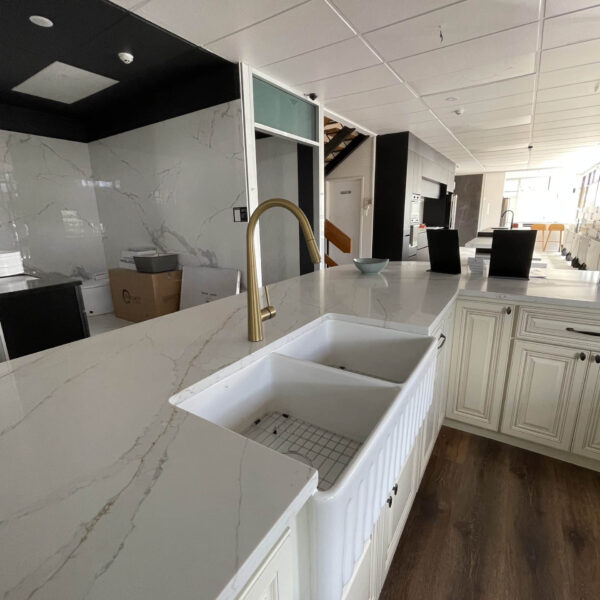 Modern kitchen with marble countertops and farmhouse sink.