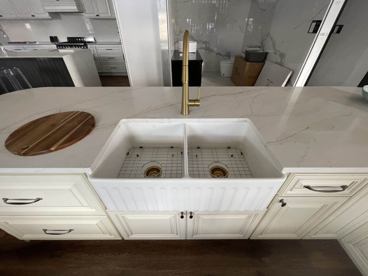 Modern kitchen with marble countertop and double farmhouse sink.