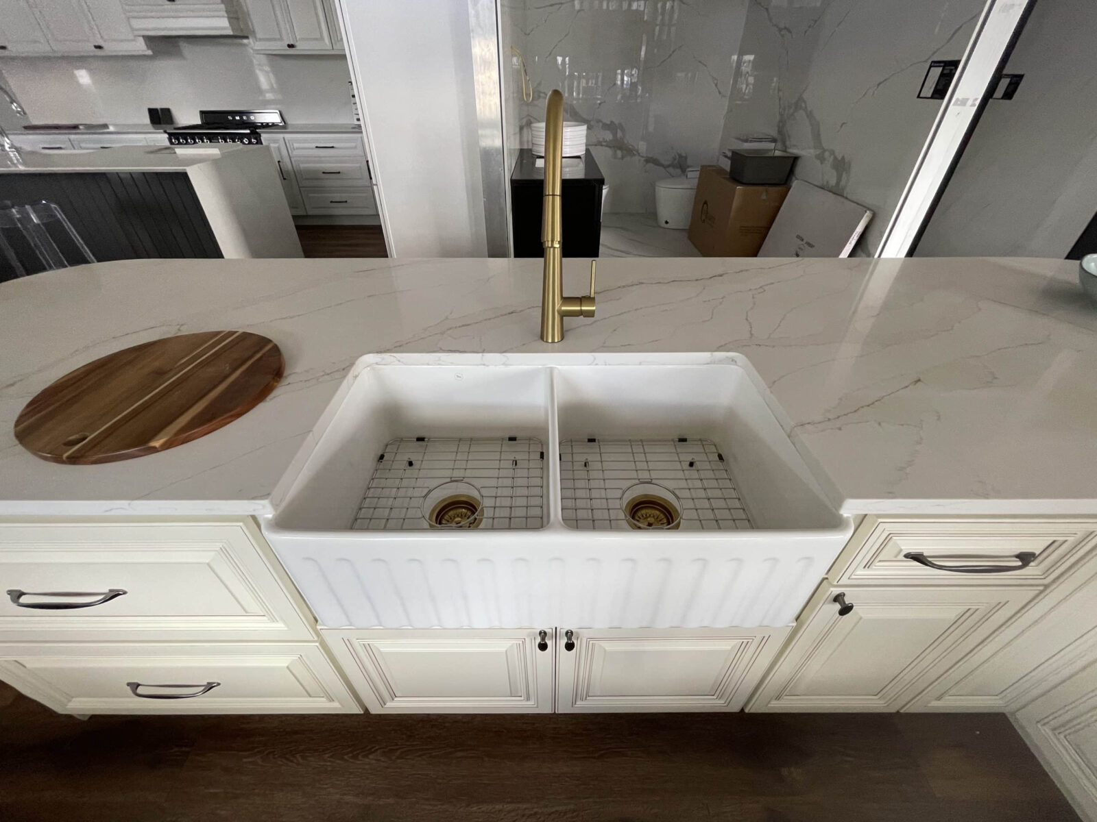 Modern kitchen with marble countertop and double farmhouse sink.