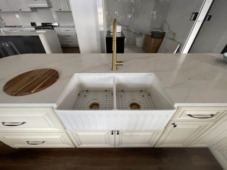 Modern kitchen with marble countertop and double farmhouse sink.