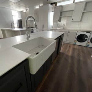 Modern kitchen with white countertops and farmhouse sink.