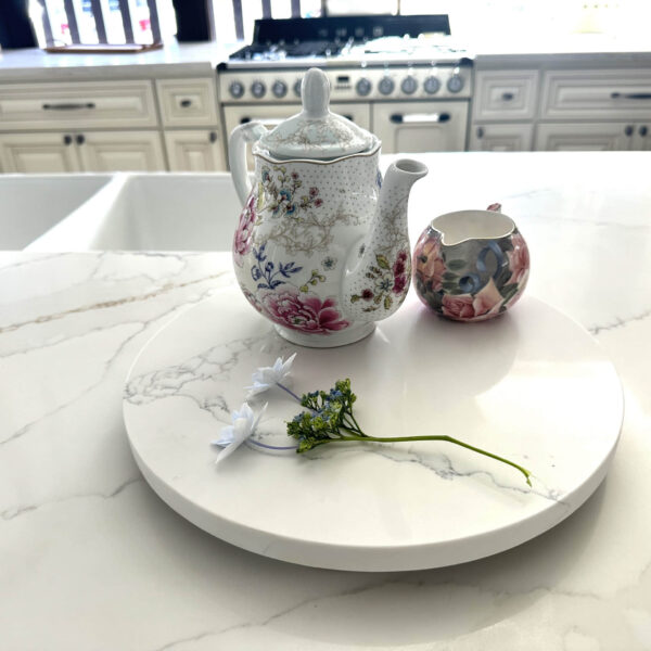 Floral teapot and creamer on marble kitchen counter.