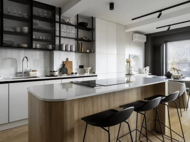 Modern kitchen with wood island, black open shelving, and minimalist white cabinets