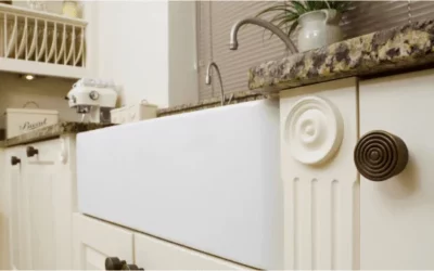 Modern white farmhouse sink integrated into traditional kitchen cabinetry with marble countertop