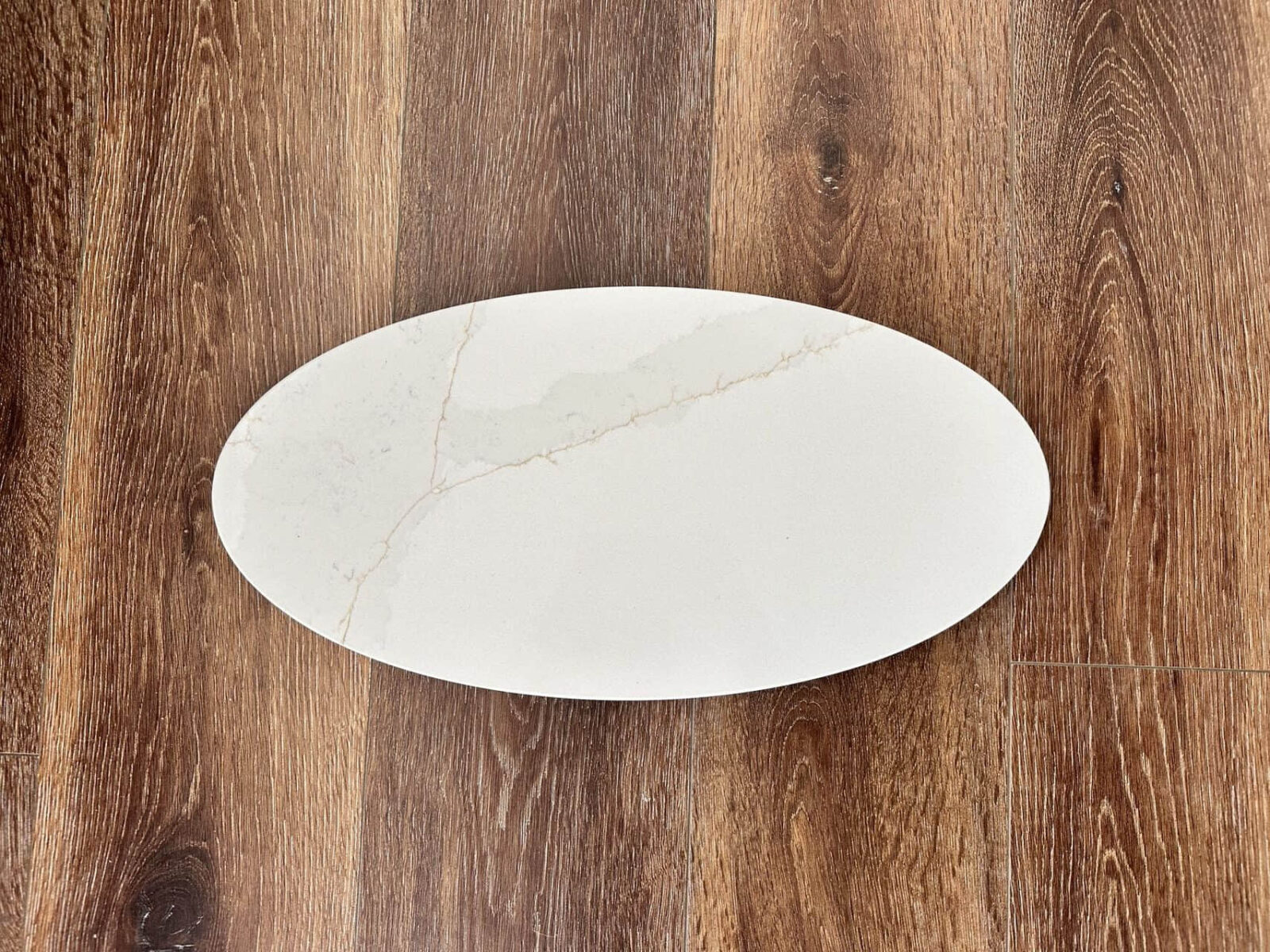 P1006 Oval marble plate on wooden floor.