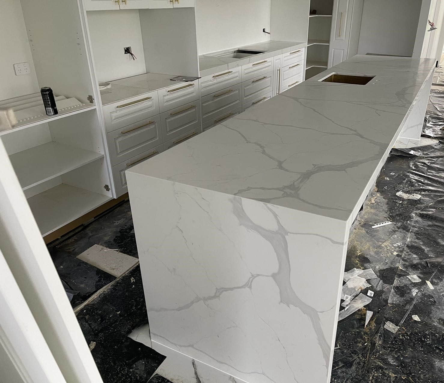 Modern kitchen with marble island countertop under construction.