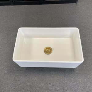 White rectangular kitchen sink on a gray countertop.
