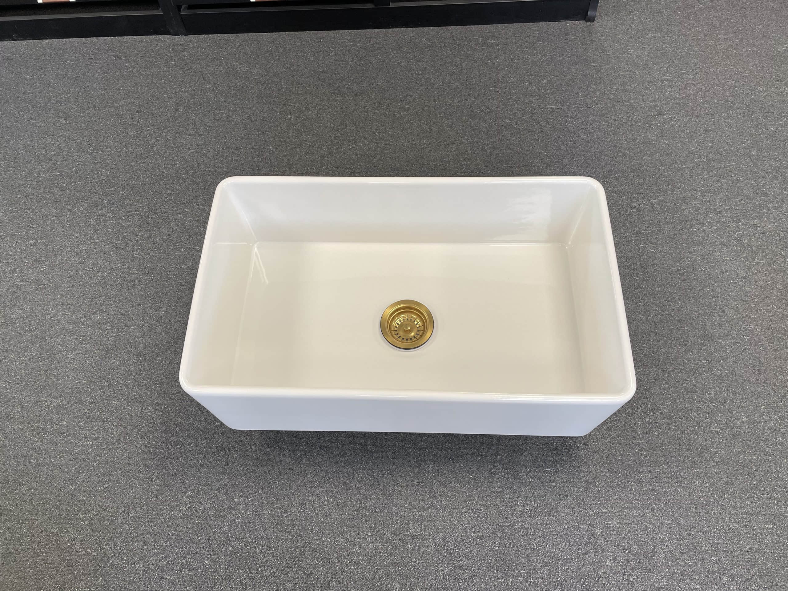 White rectangular kitchen sink on a gray countertop.