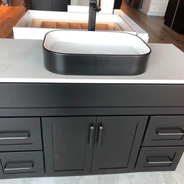 Black bathroom vanity with white countertop and rectangular sink.