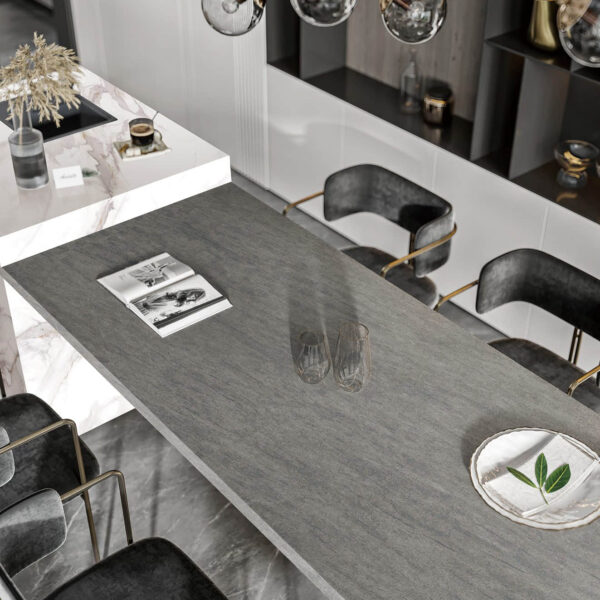 Modern kitchen with marble countertop and black chairs.