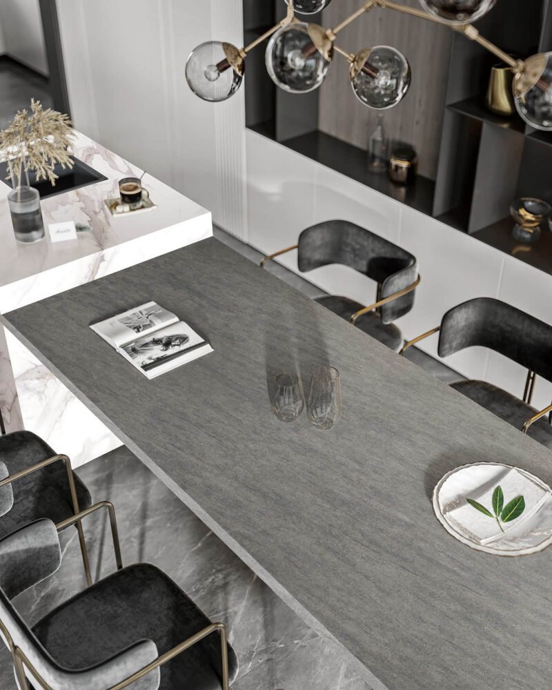 Modern kitchen with marble countertop and black chairs.