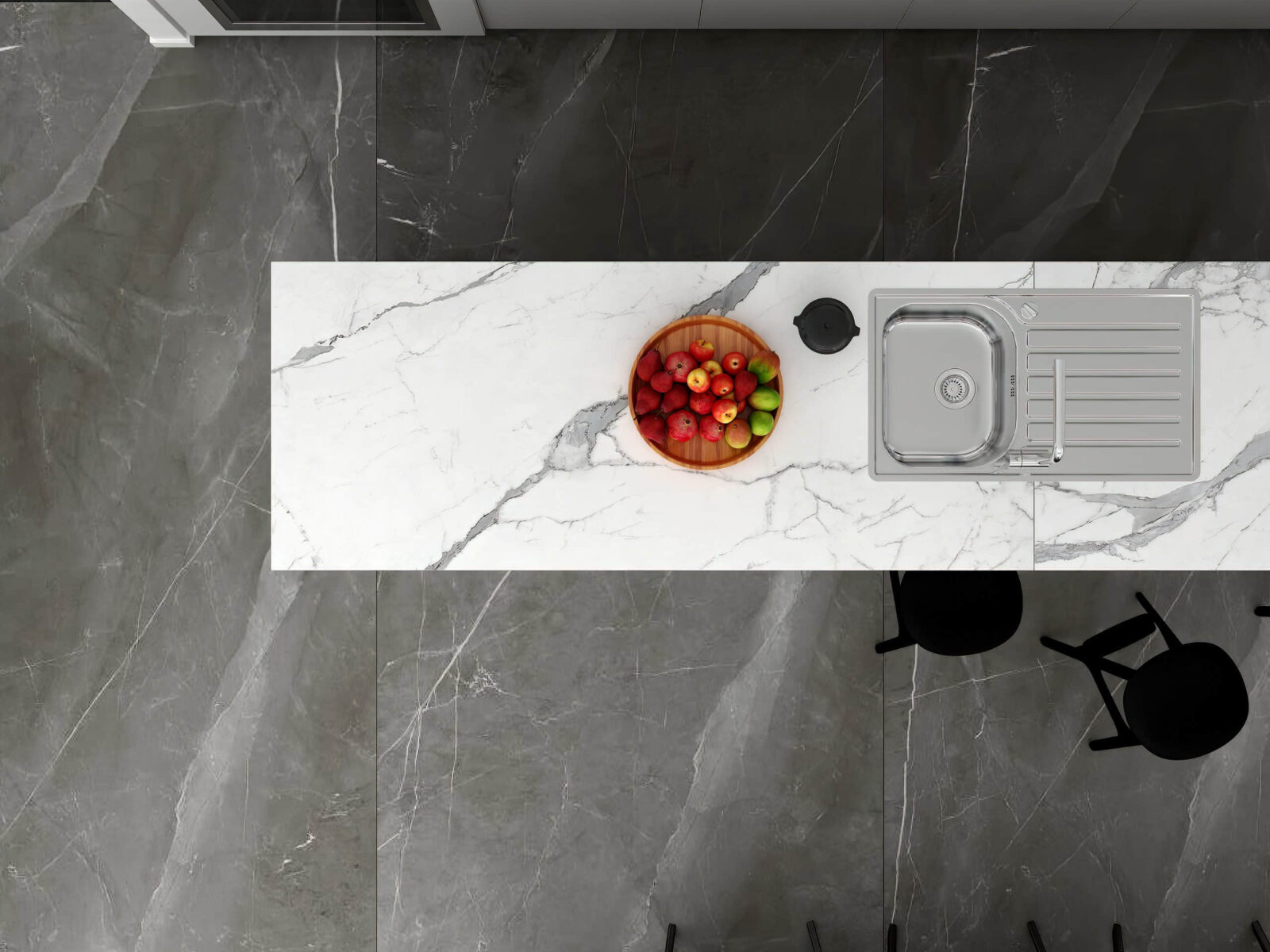 Marble kitchen countertop with fruit bowl and sink, viewed from above.