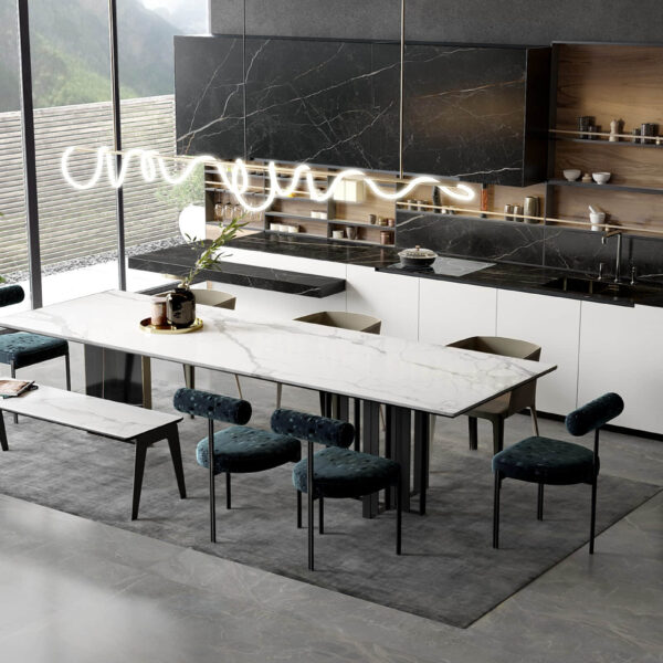 Modern kitchen with marble table, dark cabinets, and large plant.