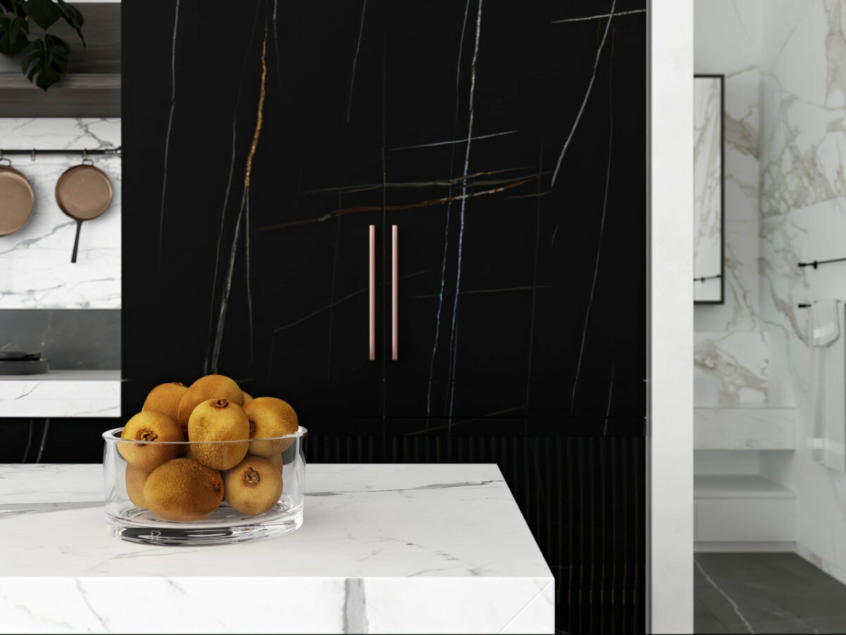 Bowl of oranges on marble counter in modern kitchen.