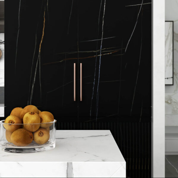 Bowl of oranges on marble counter in modern kitchen.