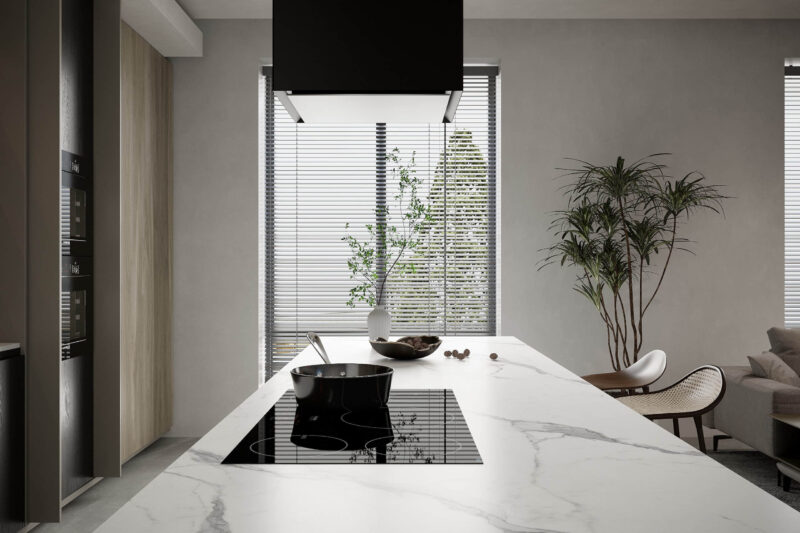 Modern kitchen island with marble countertop and induction cooktop.